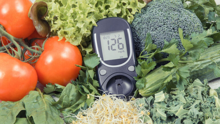 Blood sugar monitor laying amongst a bed of vegetables